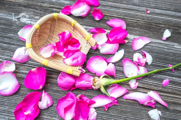 Pétalas cor-de-rosa de rosa na velha prancha — Fotografia de Stock