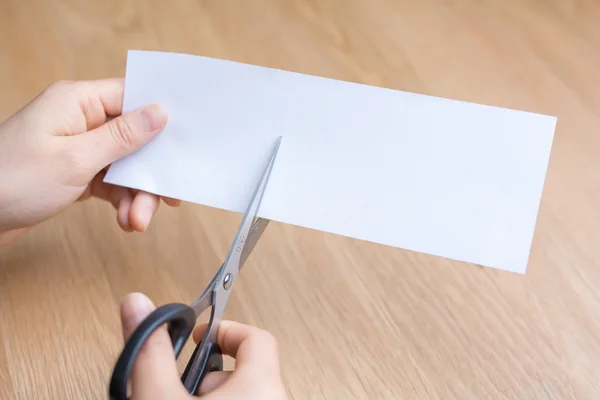 Mulher cortando papel branco — Fotografia de Stock