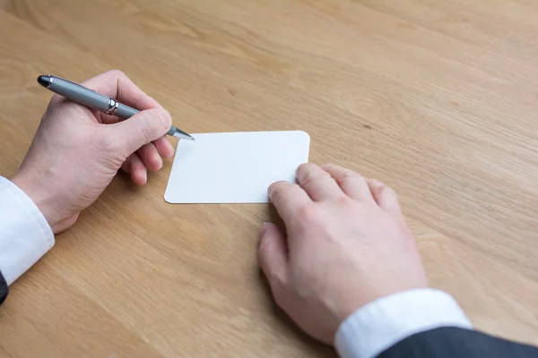 Un homme d'affaires écrit sur un livre blanc — Photo