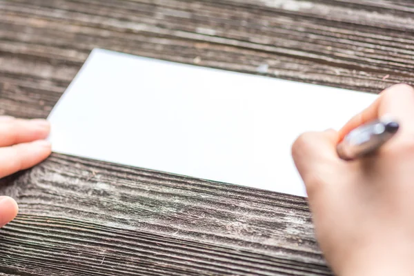 Geschäftsfrau schreibt auf weißem Papier auf den Tisch — Stockfoto
