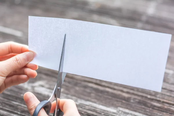 Женщина режет бумагу ножницами — стоковое фото