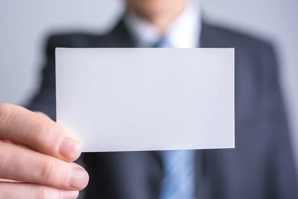 Бизнесмен, держащий в руках белую бланковую бумагу — стоковое фото