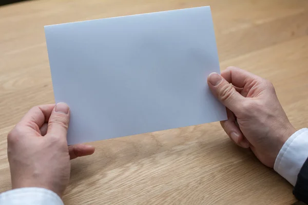 Empresário segurando papel branco em branco — Fotografia de Stock