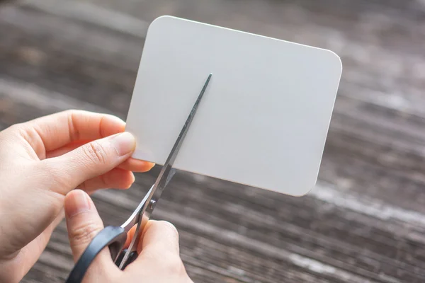 Frau schneidet Papier mit der Schere — Stockfoto