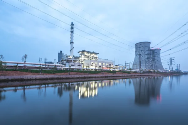 Moderna centrale elettrica vicino al fiume al crepuscolo — Foto Stock