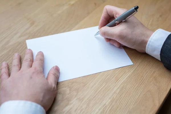 Businessman writing on white paper — Stock Photo, Image