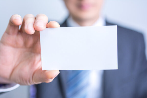 businessman holding white blank paper