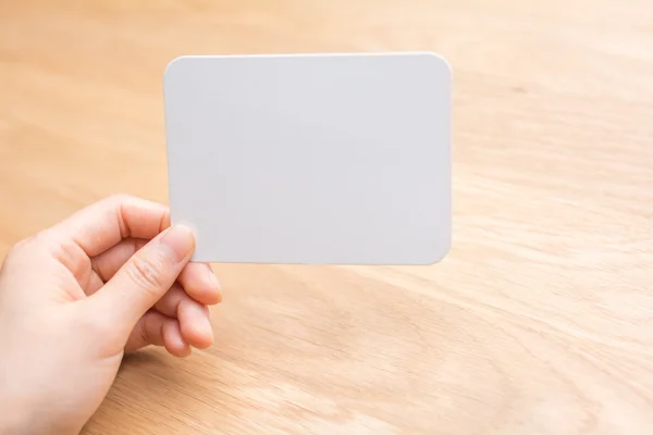 Woman's hand holding white blank paper — Stock Photo, Image