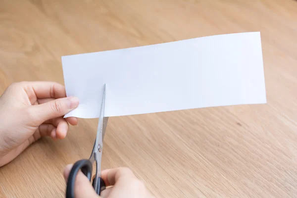 Mulher cortando papel branco — Fotografia de Stock