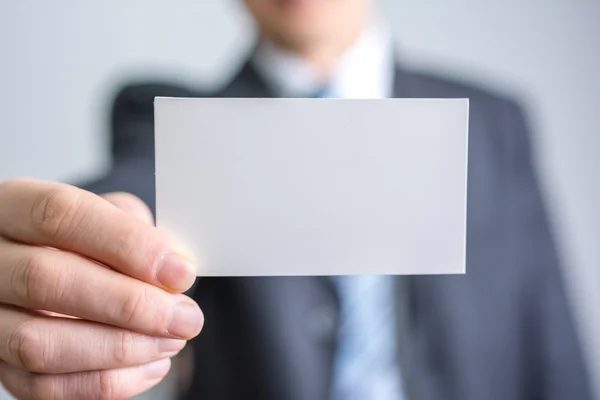 Empresário segurando papel branco em branco — Fotografia de Stock