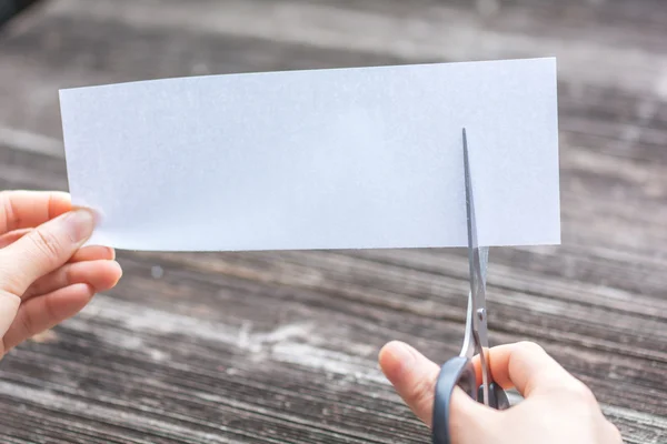 Woman cutting paper by scissors — Stock Photo, Image