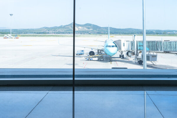 glass window and airplane in airport