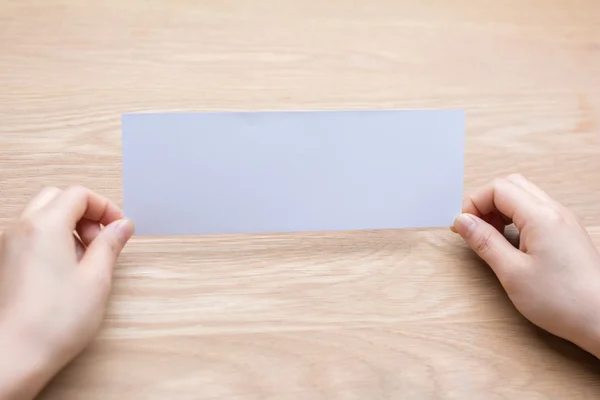 Mãos da mulher segurando papel em branco — Fotografia de Stock