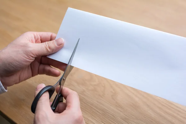businessman cutting paper by scissors