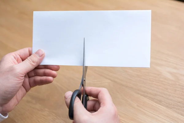Affärsman skära papper av sax — Stockfoto