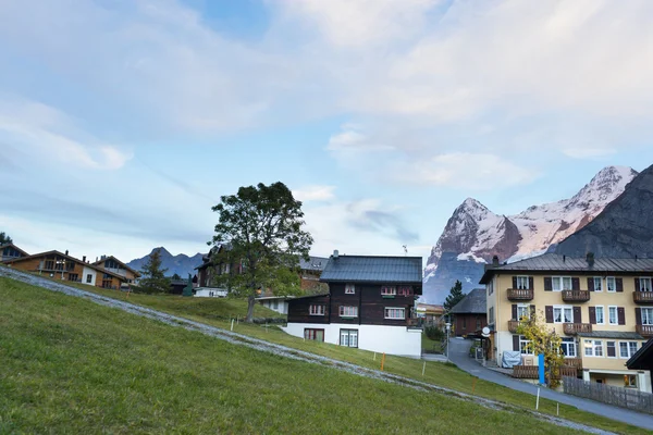 Casas de aldeia perto de Alpes montanhas na Suíça — Fotografia de Stock