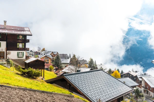 Casas de aldeia perto de Alpes montanhas na Suíça — Fotografia de Stock