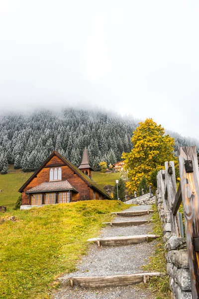 Husen i byn nära Alperna bergen i Schweiz — Stockfoto