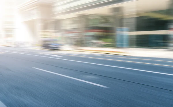 Traffico sfocato su strada vicino a edificio moderno — Foto Stock