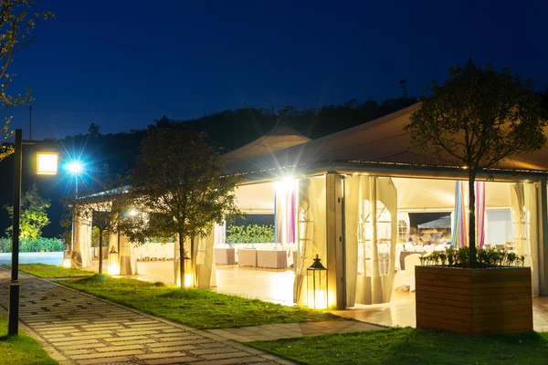 Buiten restaurant onder enorme tent bij nacht — Stockfoto