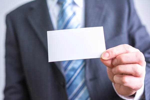 Empresário segurando papel branco em branco — Fotografia de Stock