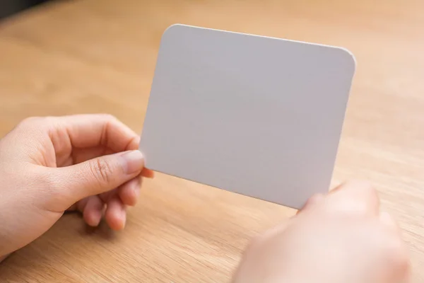 Woman's hands holding white blank paper — Stock Photo, Image