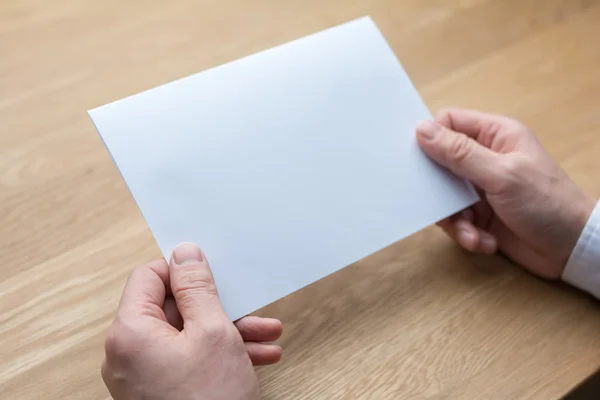 Işadamı holding beyaz boş kağıt — Stok fotoğraf