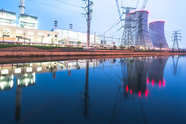 Moderna central eléctrica cerca del agua en el crepúsculo —  Fotos de Stock
