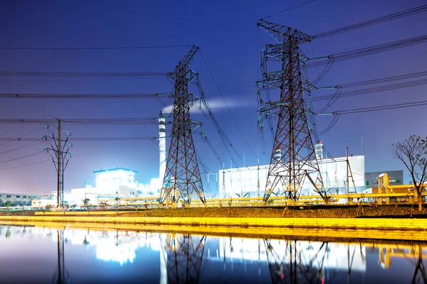 夜の水から発電所の近くの鉄塔 — ストック写真