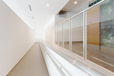 Modern ofis koridorunda tekerlekli sandalye yolu ile