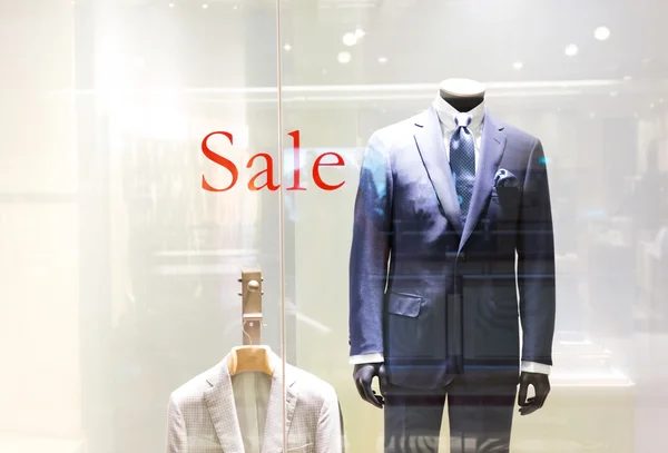 Sale sign  and cloth exhibit in window — Stock Photo, Image