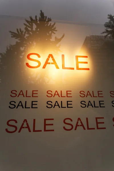 Sale poster in the display window of shop — Stock Photo, Image