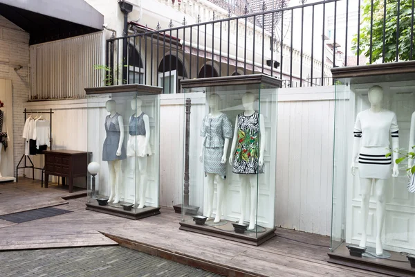 Mannequins stand in storefront glass box — Stock Photo, Image