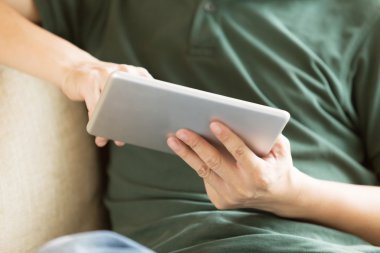 tablet kullanma ve kanepede rahatlatıcı bir adam