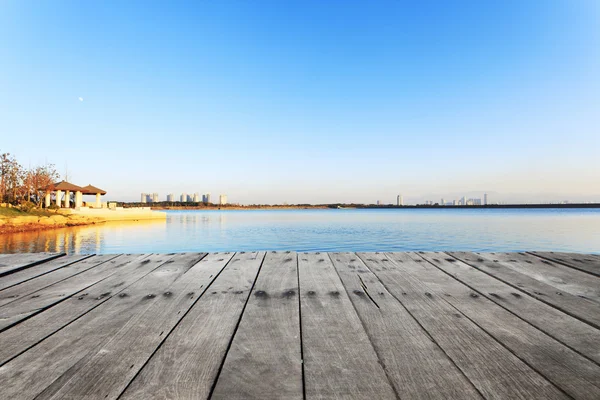 Skyline och sjön med planka styrelse nära resort i förorten. — Stockfoto