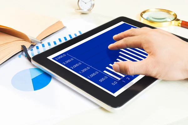 Uomo mano sul tablet digitale con rapporto grafico finanziario — Foto Stock