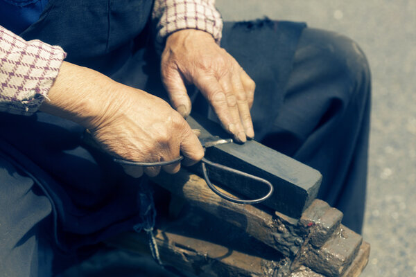 craftsman sharpen scissor with whetstone