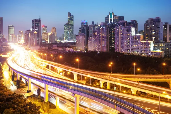 Verkeer op verhoogde expresweg aan moderne stad — Stockfoto