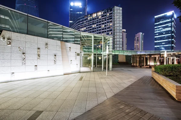 Illuminated empty footpath near modern building — Stock Photo, Image