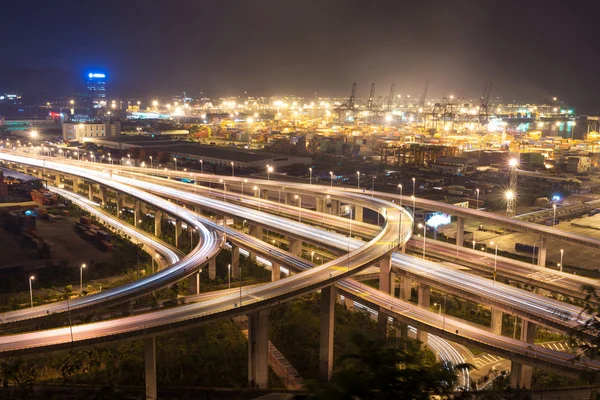 Via expressa iluminada e elevada e paisagem urbana à noite — Fotografia de Stock