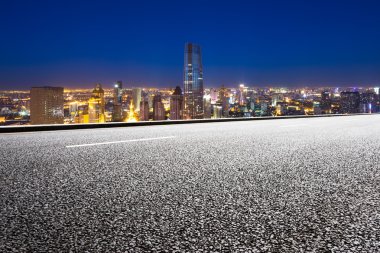 Modern şehir silueti olan boş yol