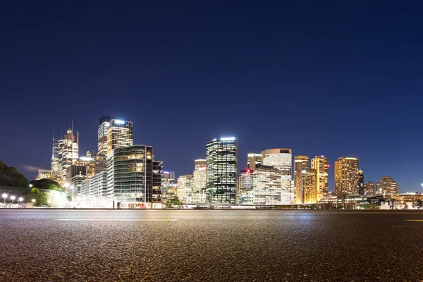 Empty road and illuminated modern cityscape — Stock Photo, Image