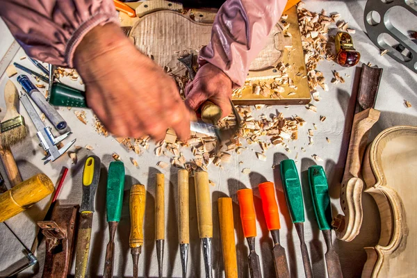 Carpenter engraving violin with tools — Stock Photo, Image