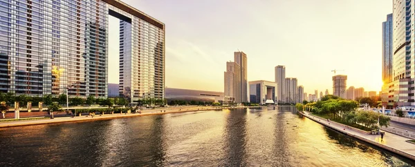 Rascacielos modernos y horizonte durante el atardecer en la orilla del río — Foto de Stock