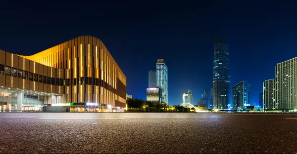 Empty asphalt road and modern skyline at night