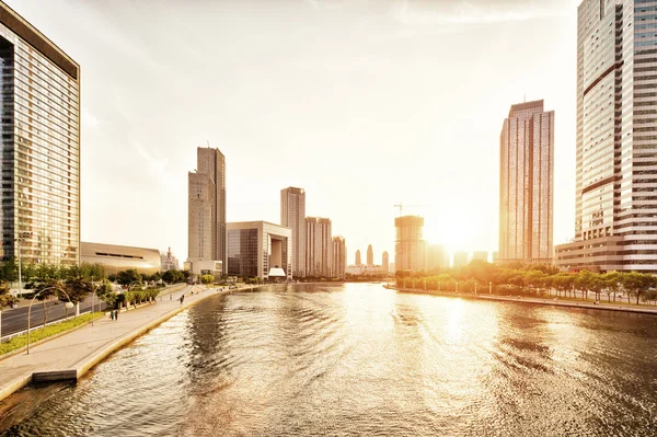 现代化的摩天大楼，天际线在日落在河岸 — 图库照片