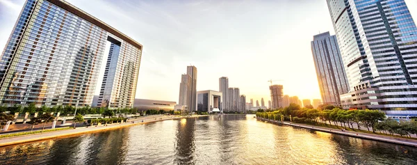 Grattacieli moderni e skyline durante il tramonto sulla riva del fiume — Foto Stock