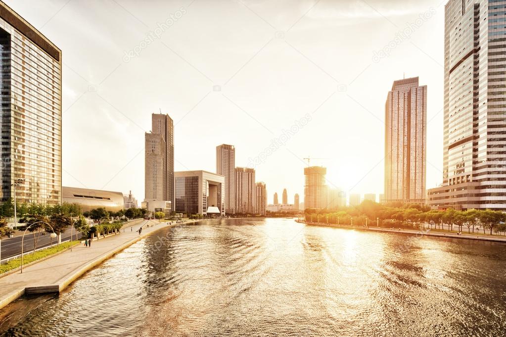 modern skyscrapers and skyline during sunset at riverbank