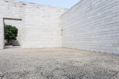 Beyaz tuğla duvar ve boş kumtaşı yol