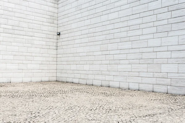 Witte bakstenen muur en lege zandsteen weg — Stockfoto